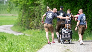 Männer ziehen mit einem Bollerwagen und Bier trinkend über einen Feldweg. Außerhalb der Kirchen erhielt der Tag Christi Himmelfahrt den Beinamen «Vatertag». Er wird mit Herrenpartien und Trinkgelagen gefeiert.