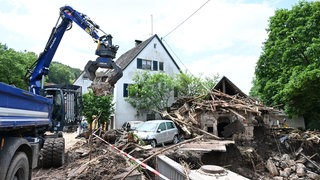 Helfer des Technischen Hilfswerks (THW) bergen Gegenstände, die durch ein Hochwasser nach einem Unwetter zerstört und angeschwemmt wurden.