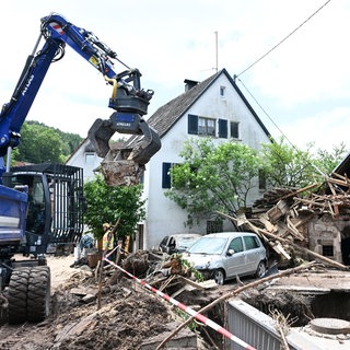 Helfer des Technischen Hilfswerks (THW) bergen Gegenstände, die durch ein Hochwasser nach einem Unwetter zerstört und angeschwemmt wurden.