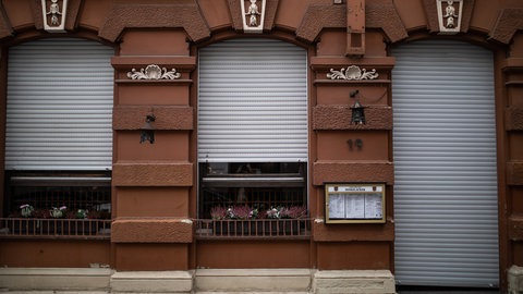 Die Rollläden eines Restaurants sind geschlossen. 