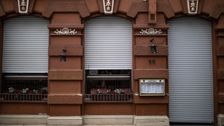 Die Rollläden eines Restaurants sind geschlossen. 