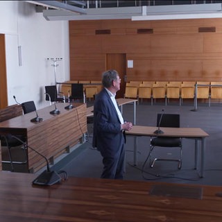 Richter Klaus-Dieter Stark steht in einem leeren Gerichtssaal des Landgerichts Freiburg