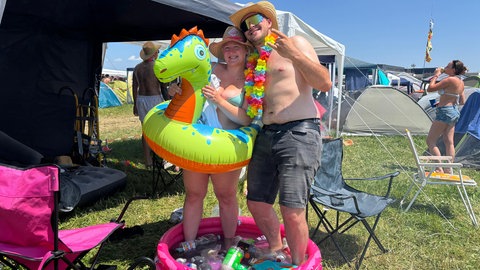 Zwei Festival-Besucher nehmen auf dem Southside 2025 in der Hitzewelle ein Fußbad. 