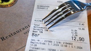 Ein Kassenbon mit einer Mehrwertsteuer von 19 Prozent für Speisen und Getränke liegt in einem Restaurant.