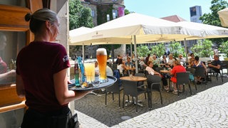 Mindestlohn im Nebenjob: Eine Studentin bedient Gäste in einem Cafe. 
