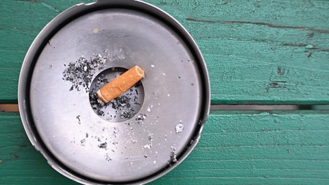 Ein Aschenbecher mit einem Zigarettenstummel darin. Die baden-württembergische Landesregierung will das Rauchverbot ausweiten.