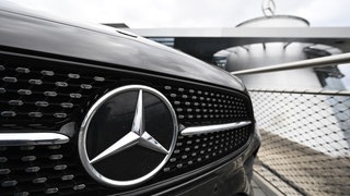 Das Logo der Automarke Mercedes-Benz ist an der Front eines Mercedes-Benz Fahrzeugs angebracht.