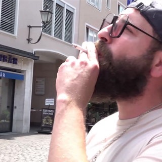 ein Mann raucht eine Zigarette