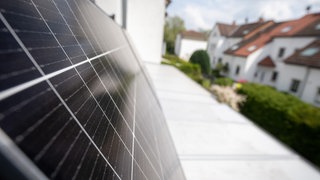 Ein Balkonkraftwerk hängt an einem Balkon.