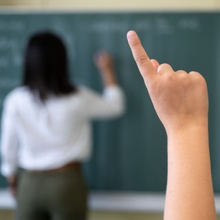  Ein Schüler meldet sich per Handzeichen in einem Klassenraum. Viele junge Lehrkräfte sind in Baden-Württemberg ohne Job.