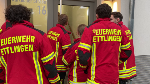 Einsatzkräfte der Feuerwehr evakuieren ein Gebäude. In Ettlingen (Kreis Karlsruhe) wurde am Montag eine Fliegerbombe gefunden.