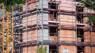 Ein Gerüst steht an der Baustelle eines Neubaus. 