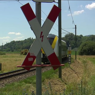 Zug fährt durch einen Bahnübergang