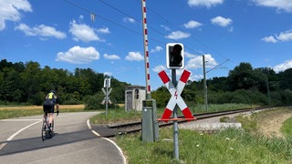 Ein Fahrradfahrer überquert einen Bahnübergang in Bahlingen am Kaiserstuhl.