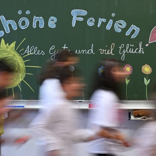 Schulkinder verlassen zum Ferienstart das Klassenzimmer.