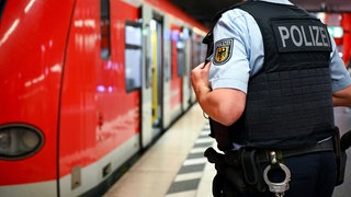 Ein Bundespolizist steht am Hauptbahnhof München an einer S-Bahn. Auch dort gilt das temporär verschärfte Waffenverbot in der Vorweihnachtszeit.