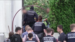 Polizisten betreten ein Grundstück