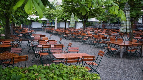 Leere, nasse Biertische in einem Biergarten: Das Regenwetter wirkt sich auf die Außengastronomie aus.