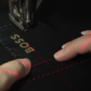 HugoBoss Logo wird auf eine Jeans genäht