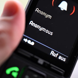Jemand hält ein Telefon, auf dem ein anonymer Anruf eingeht. (Symbolbild)