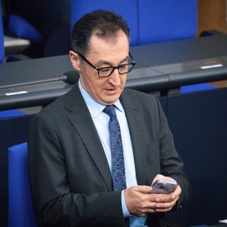 Cem Özdemir schaut im Bundestag auf sein Handy.