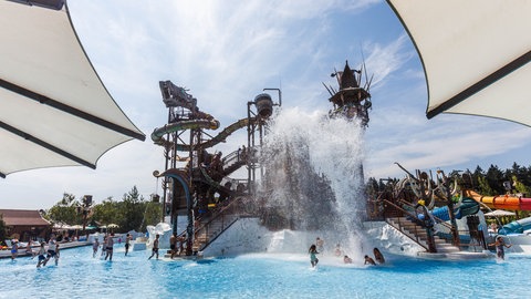 Wasser fällt aus einer Attraktion auf Menschen, die im Wasserpark Rulantica baden.