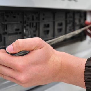 Ein Mann montiert ein Kennzeichen: Bekommen kleinere Städte bald eigene Kennzeichen? (Symbolbild)