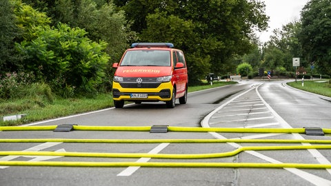 Ein Einsatzfahrzeug der Feuerwehr auf einer Landstraße zwischen Böhringen und Überlingen. Die Landstraße war nach Starkregen und Überschwemmungen in beiden Richtungen gesperrt.