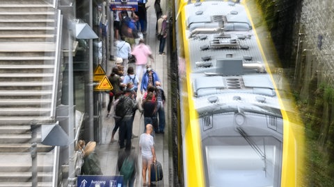 Zugreisende stehen am Bahnhof Überlingen (Bodenseekreis), um in den Zug einzusteigen.