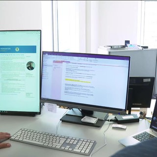 Ermittler vor einem Computer Bildschirm