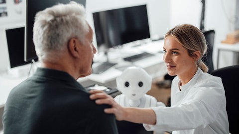 Gespräch beim Arzt mit Roboter. Für eine Beratung zum individuellen Krankheitsrisiko reichen die Daten, mit denen Delphi-2M gefüttert wurde, nicht aus. Sie verfolgt ein weitgefassteres Ziel.