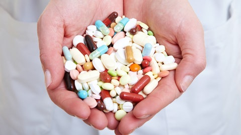 Zwei Hände voller Tabletten. Eine Überbewertung des Krankheitsrisikos kann zur Überbehandlung führen.