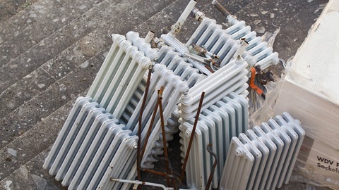 Alte ausrangierte Heizkörper liegen nach einer Gebäude-Sanierung in einem Innenhof.