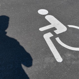Ein Rollstuhl-Symbol auf Asphalt. In BW führt in 25 Prozent der Fälle ein Widerspruch gegen eine Ablehnung oder Höherstufung des Behindertengrades zum Erfolg. (Symbolbild)