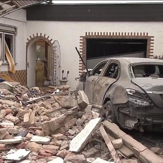 Eingestürztes und in Trümmer liegendes Haus und Auto