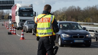 Ein Beamter der Bundespolizei kontrolliert Fahrzeuge an der Grenze zu Frankreich.