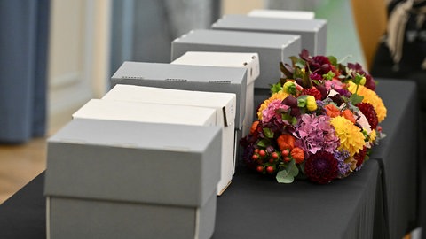 Blumen liegen vor Kartons mit menschlichen Gebeinen, die im Rahmen einer Rückgabezeremonie an die Republik Marshallinseln übergeben werden.
