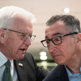 Archivbild | Der designierte Spitzenkandidat der Grünen in Baden-Württemberg, Cem Özdemir (r) und Winfried Kretschmann (Bündnis 90Die Grünen), unterhalten sich vor Beginn des Landesparteitags der Grünen in Baden-Württemberg.