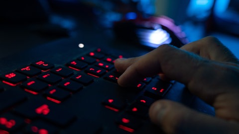 Ein Mann sitzt am Rechner und tippt auf einer Tastatur. Mehr als 1.400 betrügerische Internetseiten von Cyberkriminellen in BW beschlagnahmt.
