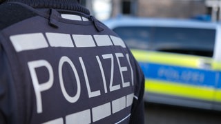 Ein Polizist in Dienstkleidung. Die Polizei vermutet bei der Amokdrohung an der Realschule in Öhringen einen TikTok-Trend.