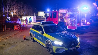 Einsatzfahrzeuge von Polizei und Feuerwehr stehen auf einem Parkplatz in Rechberghausen (Kreis Göppingen). In dem Ort hat sich am Montag ein tödlicher Unfall ereignet.