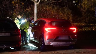 Zwei Einsatzkräfte stehen neben einem roten Auto und leuchten mit der Taschenlampe darauf. In Rechberghausen ist es zu einem tödlichen Unfall gekommen.