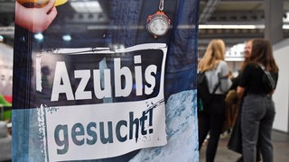 "Azubis gesucht" steht auf einem Banner bei der Berufsorientierungsmesse "Forum Berufsstart". 