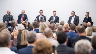Die Spitzenkandidaten zur Landtagswahl in Baden-Württemberg, Kim Sophie Bohnen (Linke, r-l), Hans-Ulrich Rülke (FDP), Manuel Hagel (CDU), Cem Özdemir (Grünen), Andreas Stoch (SPD) und Markus Frohnmaier (AfD) sitzen bei einer Veranstaltung der BWIHK auf der Bühne.