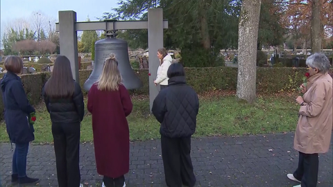 Berufsschülerinnen stehen auf dem Friedhof in Bad Saulgau (Kreis Sigmaringen) mit Rosen in der Hand. Vor ihnen eine riesige Glocke und Soldatengräber. In Bad Saulgau gab es während des NS-Regimes Zwangsarbeiter - in einem Außenlager des KZ Dachau. Beim Gedenken am Volkstrauertag dabei zu sein ist den Schülerinnen wichtig.