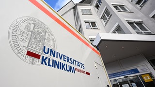 In das Uiversitätsklinikum Freiburg fährt ein Krankenwagen ein. Die Klinik muss nach einem Behandlungsfehler eine Entschädigung zahlen.