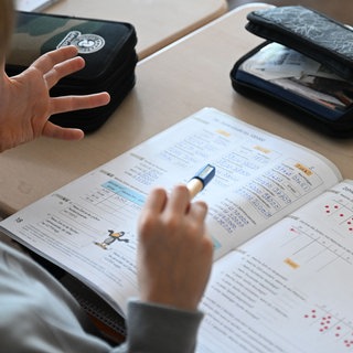 Symbolbild: In einer Grundschule arbeitet ein Schüler einer vierten Klasse an in einem Heft an seinen Mathe-Aufgaben. 