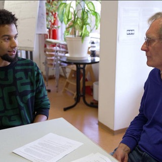 Ein junger Mann redet mit einem älteren Mann über den Kriegsdienst