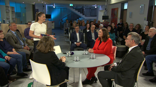 Moderatorin Alexandra Gondorf mit Gästen an einem Tisch.