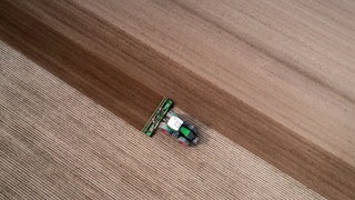 Ein Traktor zieht eine Egge über ein Feld.
